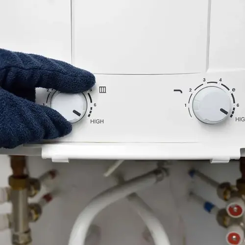 Adjusting a tankless hot water heater. RJ Plumbing Services offers new hot water installation for residential and commercial buildings.